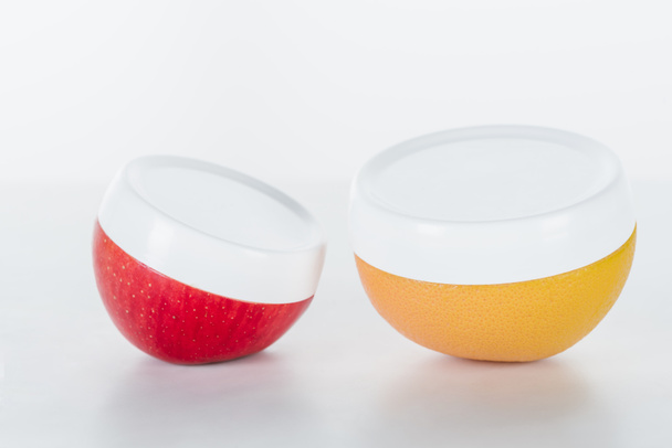 krem beyaz yüzey, güzellik kavramı kırmızı ve turuncu şişe - Fotoğraf, Görsel