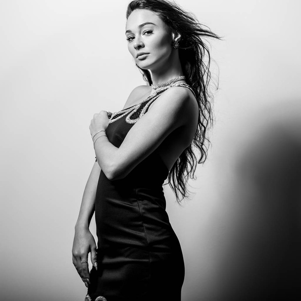 Young sensual woman in classic dress black-white studio portrait. - Valokuva, kuva