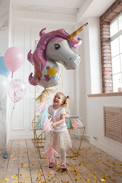 fun birthday with pretty little girl. Festive party with a unicorn, indoor - Фото, изображение