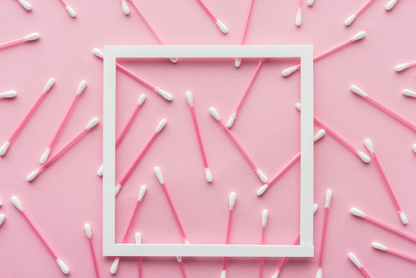 top view of cotton swabs with white frame isolated on pink, beauty concept - Foto, afbeelding