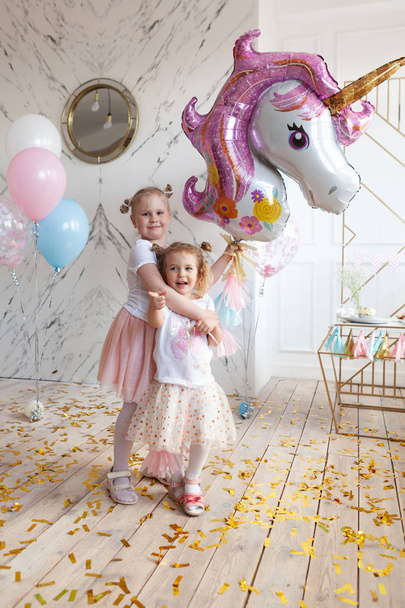 fun birthday with pretty little girl. Festive party with a unicorn, indoor - Foto, afbeelding