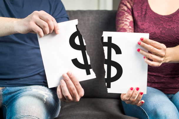 Luta sobre dinheiro ou conceito de argumento financeiro. Homem e mulher segurando papel rasgado com sinal de dólar
. - Foto, Imagem