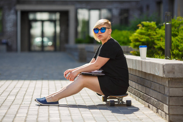 Girl student sitting on skateboard - Фото, зображення