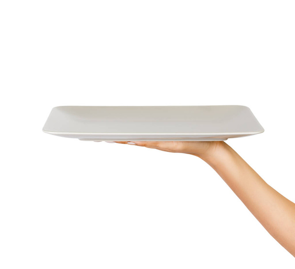 Blank white matte rectangular plate in female hand. perspective view, isolated on white background. - Photo, Image