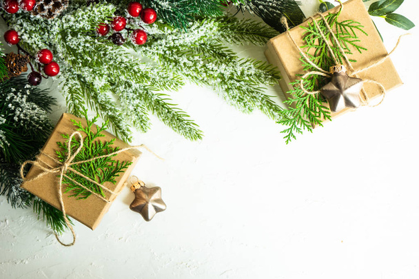 Kerst frame met geschenkdozen en christmas decor op de achtergrond van de witte cocnrete met kopie ruimte - Foto, afbeelding