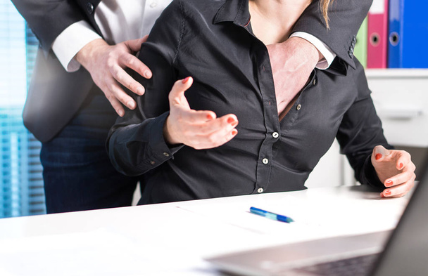 Sexual harassment and abuse at work concept. Man groping woman in business office. Boss putting hand inside her shirt and touching breasts without permission. - Фото, зображення