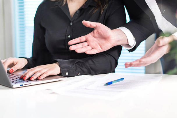 Disappointed or angry boss yelling at employee. Unhappy manager talking to bad assistant or secretary. Businessman spreading hands in office with coworker woman. Business discussion or problem. - Photo, Image