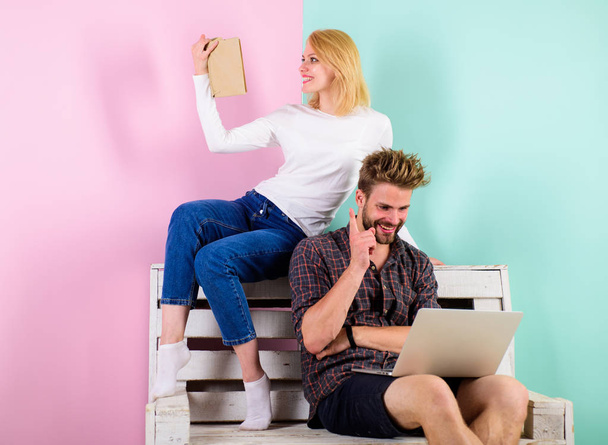 Couple with different interests spend time together. Focus of interest. Girl and guy interested in intellectual activity. Man with laptop and woman with book enthusiastic intellectual activity - 写真・画像