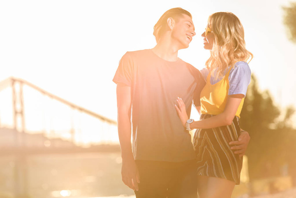 giovane coppia abbracciare e andare a baciare sulla spiaggia del fiume in serata
 - Foto, immagini