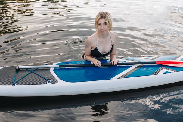 jolie fille blonde avec planche à pagaie dans l'eau
 - Photo, image