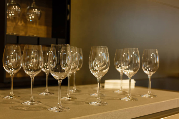 Empty clean drinking wine glasses upside down; bar counter top; black background; - Fotografie, Obrázek
