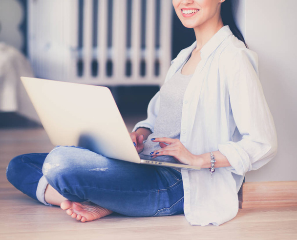 Young beautiful woman at home sitting on the floor with laptop - Φωτογραφία, εικόνα