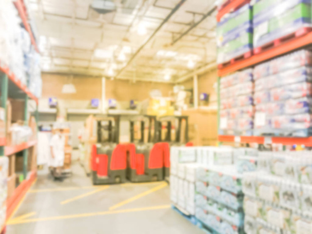 Blurred row of forklifts at large warehouse for stacking unloading goods. Defocused industrial distribution interior row aisles, shelves from floor to ceiling in America. Inventory, wholesale concept - Photo, Image