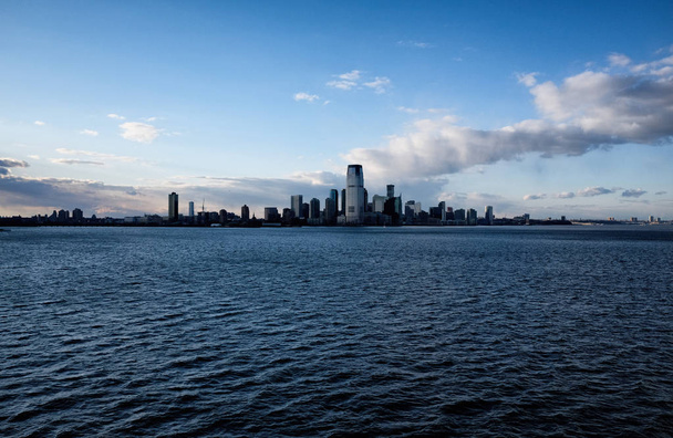 New York City skyline with urban skyscrapers over Hudson River. Manhattan downtown panorama. Waterfront view to the harbor at sunset - Fotó, kép
