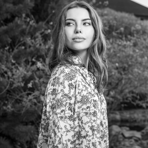Black-white portrait of beautiful young woman posing in summer garden. - Foto, Bild