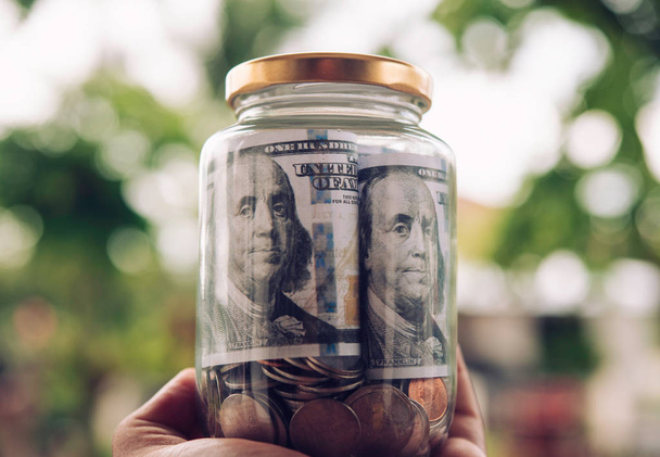Hand met jar in munten sparen geld, financiën en investeringen Concept  - Foto, afbeelding