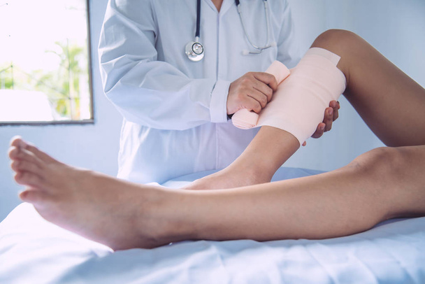 足の怪我の患者を治療している医師  - 写真・画像