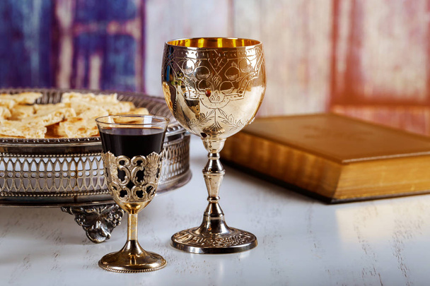 Santa comunión en la mesa de madera en la iglesia. Copa de copa con vino tinto, pan sobre mesa de madera y Santa Biblia
 - Foto, Imagen