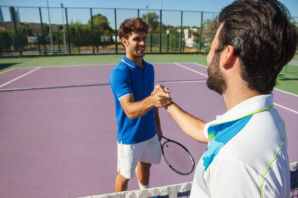 Dva profesionální tenisté drží ruce nad tenisové čisté před zápasem. - Fotografie, Obrázek