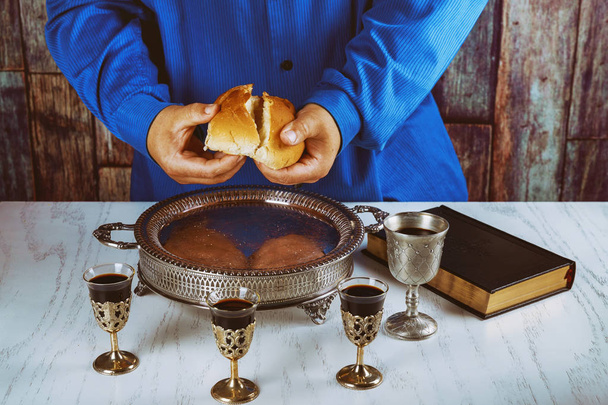 Ehtoollinen asetelma viini, leipä ja Raamattu, leivän murtaminen kirkossa ehtoollisen aikana
 - Valokuva, kuva