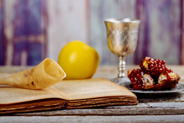 Torá, manzana y granada sobre tabla de madera shofar, miel y granada sobre fondo bokeh
 - Foto, Imagen