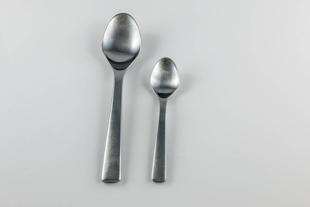Cubertería de acero con cuchara de mesa y cucharita
 - Foto, imagen