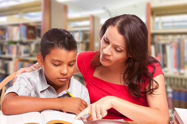 Latino jongen en Famle volwassene studeren aan bibliotheek. - Foto, afbeelding