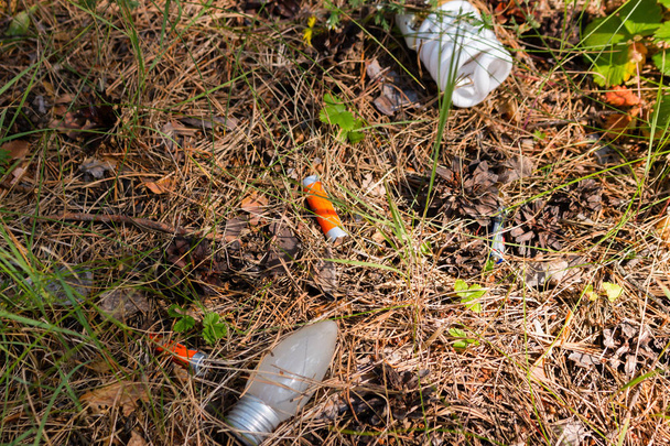 hazardous waste - light bulbs and batteries thrown in the woods - Foto, imagen