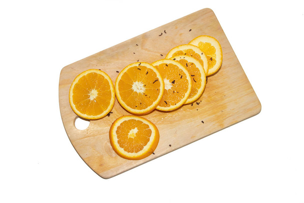 Naranja en rodajas sobre una tabla aislada sobre fondo blanco. Frutas en el tablero. Frutos sobre fondo blanco. Cortando fruta. Fruta en rodajas
 - Foto, imagen