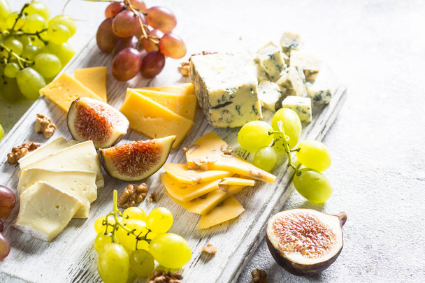 Cheese plate with grapes, figs and nuts.  - Φωτογραφία, εικόνα