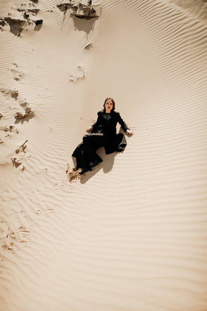 Dziewczyna w czarnym na pustyni  - Zdjęcie, obraz