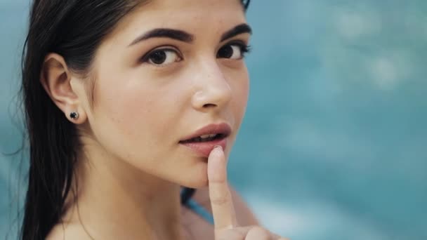 Jonge sexy vrouw in blauwe zwembroek poseren in zwembad met turkoois water, close-up - Video