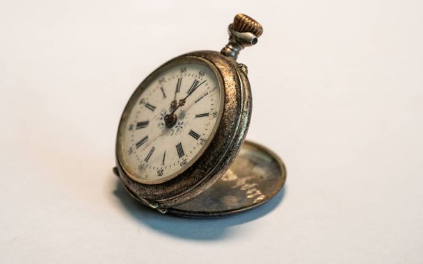 αντίκα vintage ρολόι πολύ παλιό μικρό ρολόι τσέπης σκουριασμένο λευκό φόντο στούντιο φως - Φωτογραφία, εικόνα