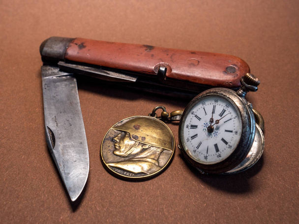 old soldier belongings vintage antique military pocket knife with pocket clock and soldier emplem brown background world war 2 old - Photo, Image