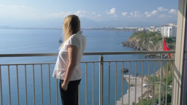 A woman talking to the phone on a hotel balcony against the beautiful scenery - Imágenes, Vídeo
