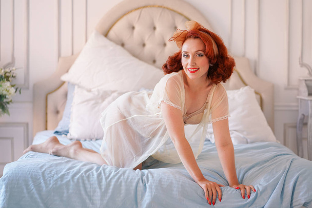 eine luxuriöse Pin-Up-Dame in beiger Vintage-Dessous posiert allein in ihrem Schlafzimmer - Foto, Bild