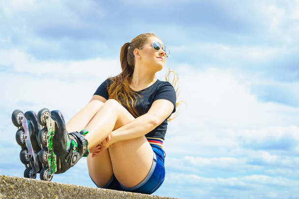Young woman wearing roller skates outdoor. Fashionable fit girl having fun resting at sunny summer day. - Foto, Imagem