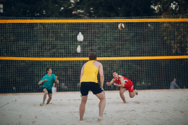 Молоді люди грають у пляжний волейбол
 - Фото, зображення