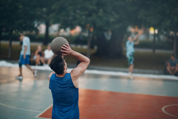 El tipo juega baloncesto y lanza la pelota al ring
 - Foto, imagen