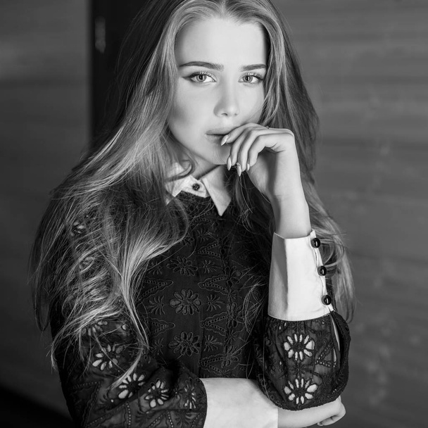 Young beauty woman against house interior. Black-white photo. - Фото, зображення