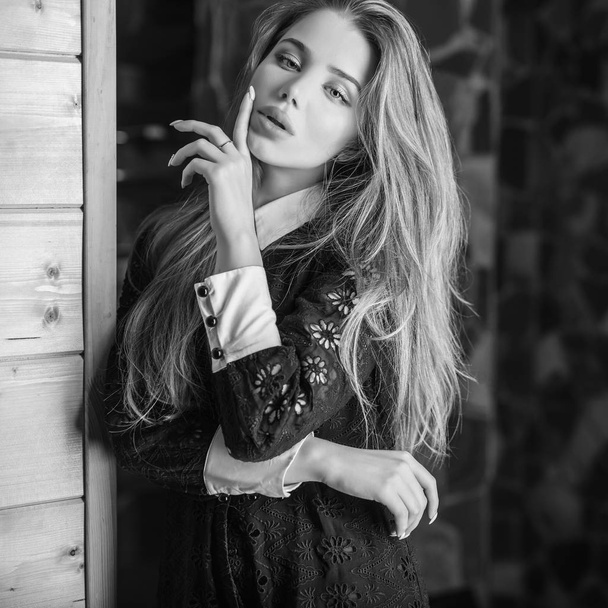 Young beauty woman against house interior. Black-white photo. - Foto, Bild
