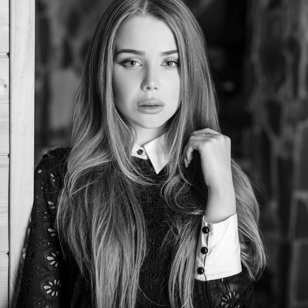 Young beauty woman against house interior. Black-white photo. - Foto, Imagem