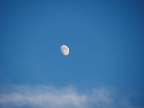 Dorůstající srpek měsíce nad modrou oblohu s mraky - Fotografie, Obrázek