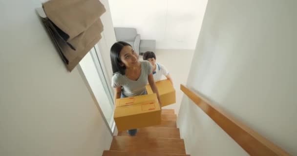 Happy asian women LGBT lesbian couple holding boxes entering new modern house - Záběry, video