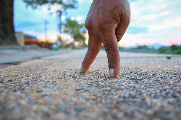 dedo de la mano caminando en la piedra de la pasarela en el parque público seleccionar el enfoque con poca profundidad de campo
. - Foto, imagen