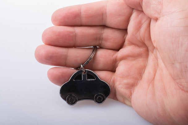 αυτοκινητική επιχειρηματική ιδέα με ένα εικονίδιο μεταλλικό αυτοκίνητο στο χέρι - Φωτογραφία, εικόνα