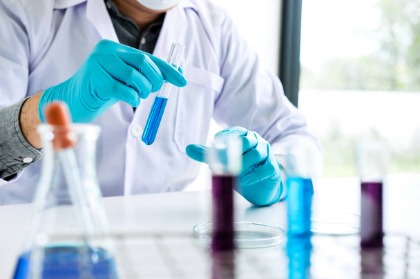 Biokémiai laboratóriumi kutatás, Vegyész analizálja mintát laboratóriumi berendezések és tudományos kísérletek üvegáruk tartalmazó kémiai folyadék. - Fotó, kép