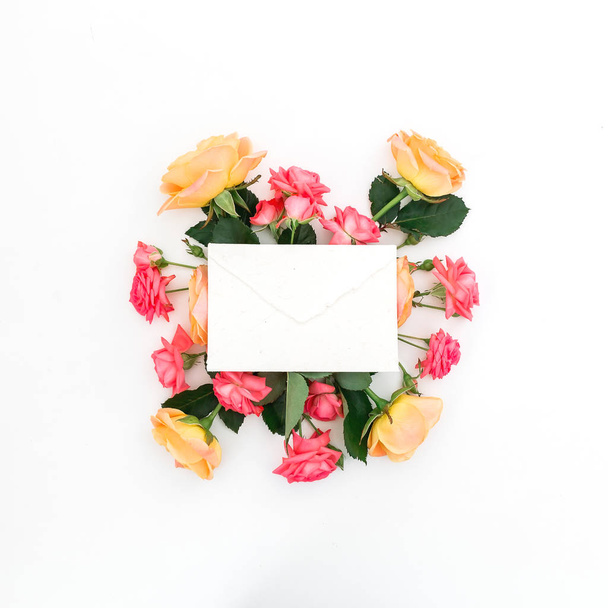 pink and yellow roses with white envelope isolated on white background, top view  - Photo, Image