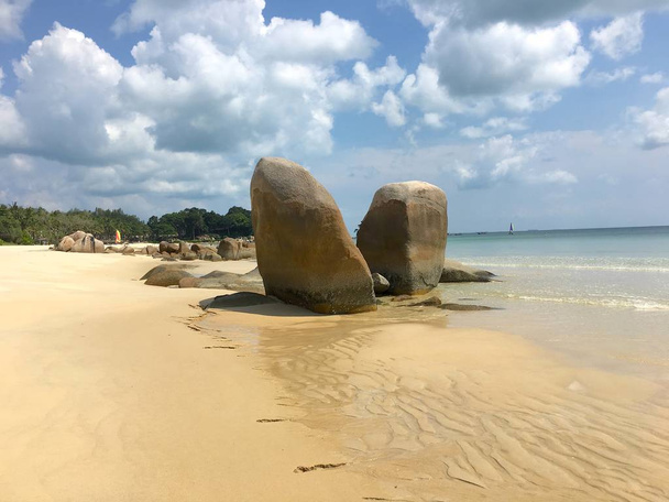 Destacado dúo de rocas entre la arena y el mar en la playa de arena blanca
 - Foto, Imagen
