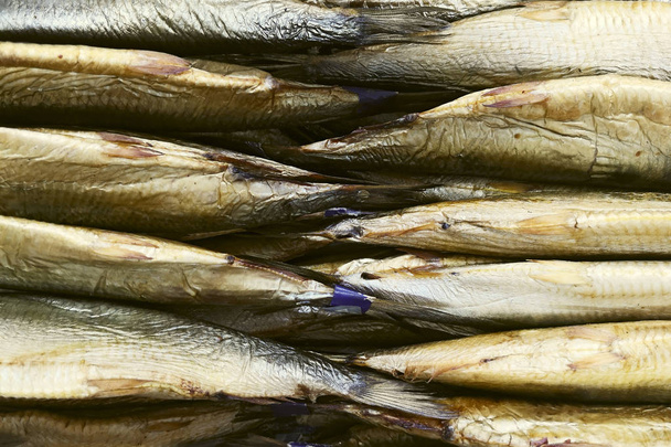 Fish shop, fish on counter. Tails of smoked fish on the counter in the store - Photo, Image
